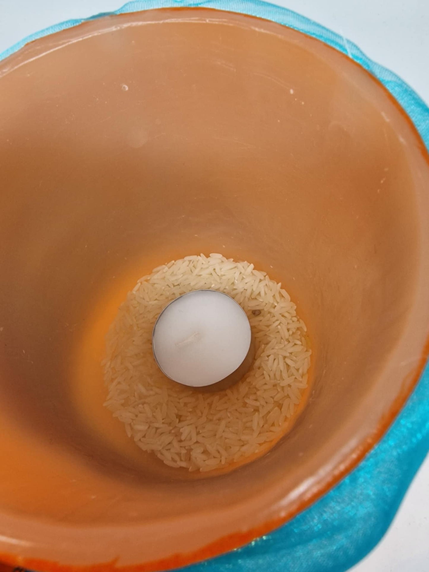 Oranje kaarslantaarn met sjaal en schelp